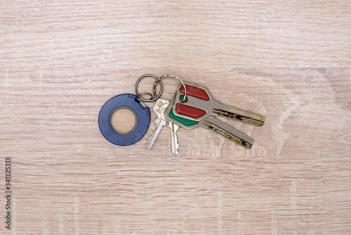 Old two large keys, two small keys and a keychain lie on a wooden background, on the table