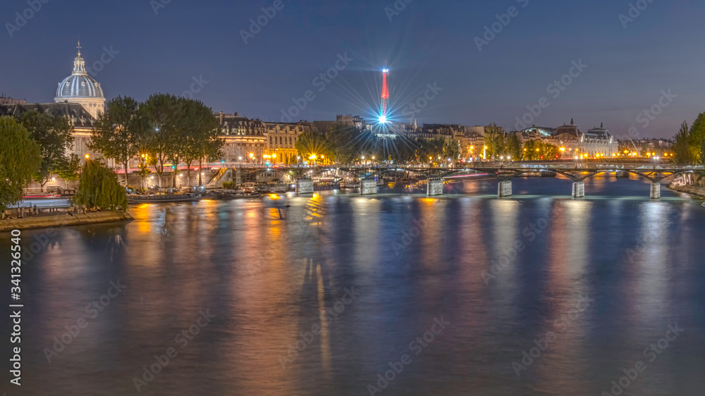 River Seine with Pont des Arts and Institut de France panorama at night in Paris, France.