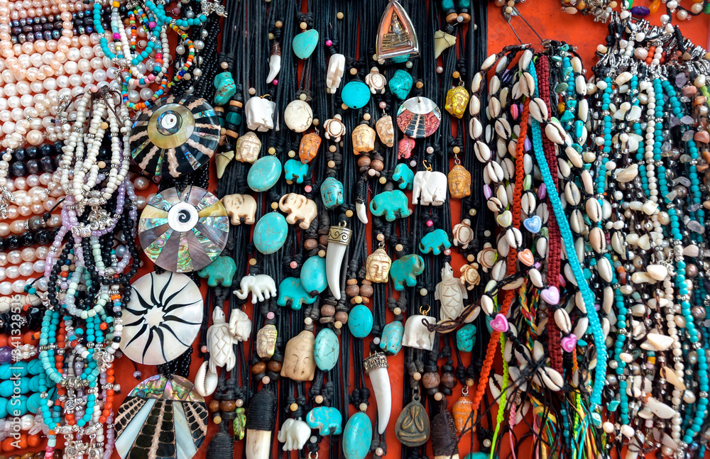Many colorful necklace, seashell bracelets, fangs as amulets and other jewelry for sale. Exotic souvenirs made from natural minerals.