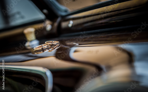 Wedding rings in old car interior. Car dashboard. Abstract ring shot.