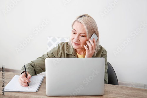Mature woman using laptop f...