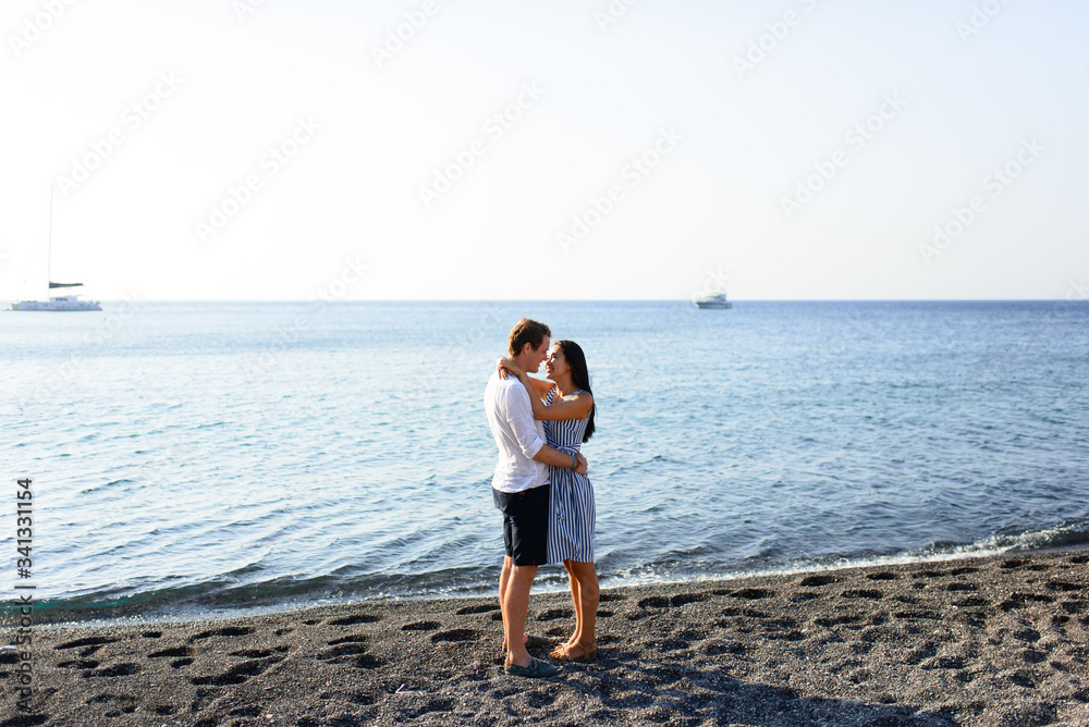 Young beautiful couple kissing on sea background.
