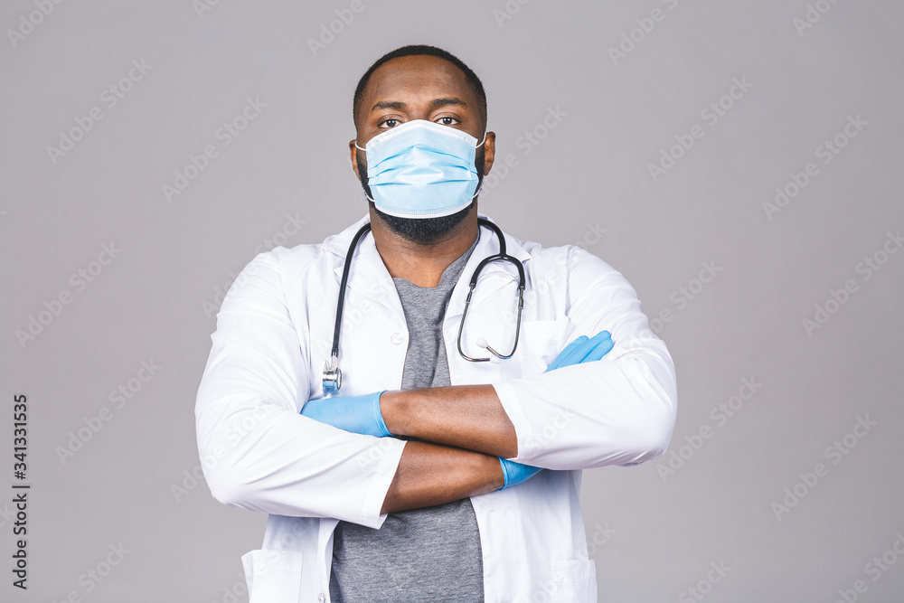 African american doctor Wearing Medical Mask and Gloves Isolated over grey background. Crossed arms. African american doctor Wearing Medical Mask and Gloves Isolated over grey background. Crossed arms.