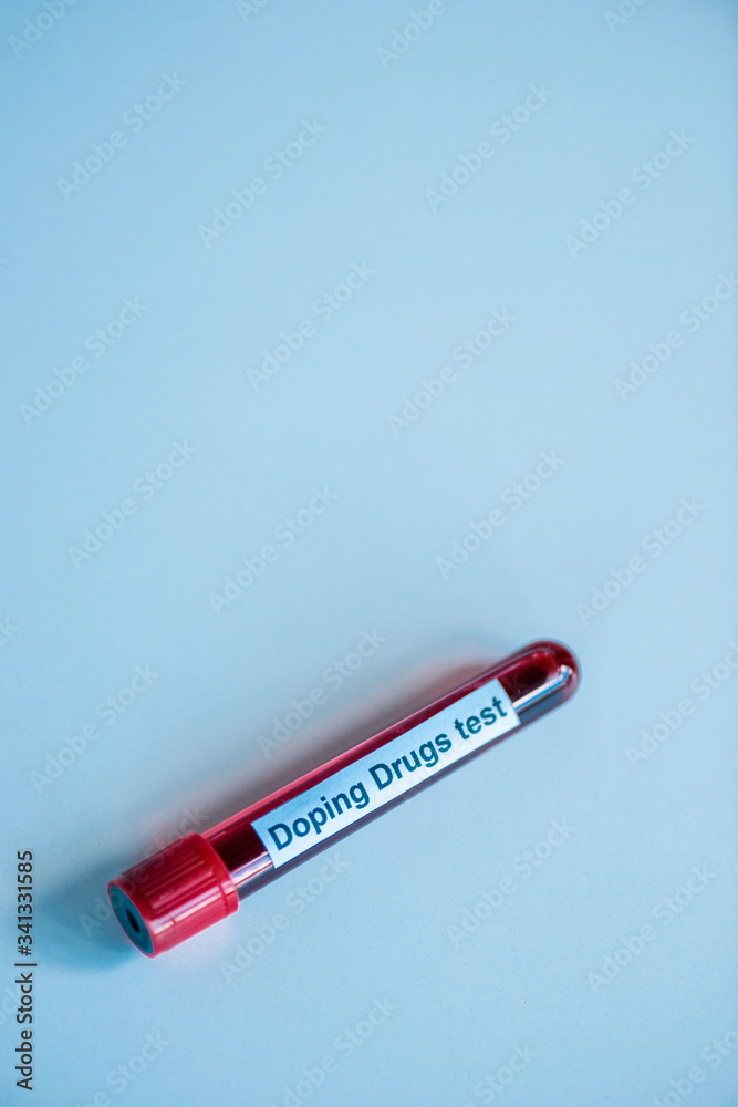 top view of glass test tube with blood sample and doping drugs test lettering on blue top view of glass test tube with blood sample and doping drugs test lettering on blue