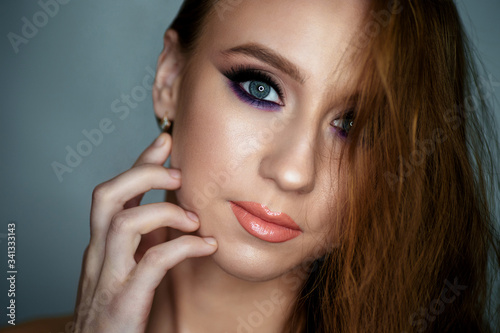 Portrait of a young woman with beautiful evening make-up on a dark background