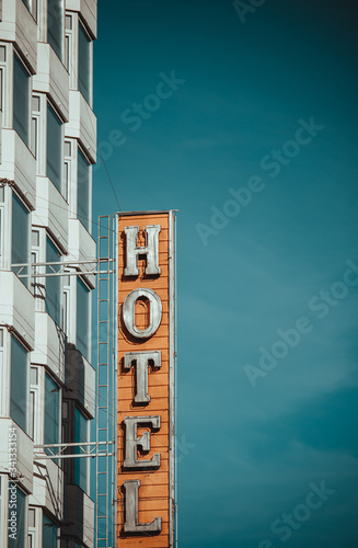 Modern hotel building and sign with blue sky behind.
