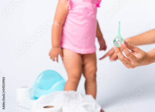 baby child girl training to sitting on blue chamber pot or potty her problem cannot shit and mother use Enema photo