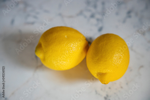Lemon. Two fresh ripe lemons isolated on a marble table