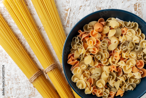ceramic blue bowl with multicolored paste on a white and beige textured background