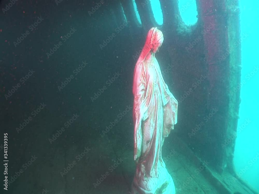 mother mary statue underwater in an airplane wreck under ocean Stock