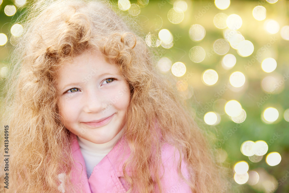 Happy girl outdoors. Quarantine end. Bokeh lights background. Smiling female portrait. Pretty blond caucasian kid. Horizontal. Not look at camera. Little woman thinking Happy girl outdoors. Quarantine end. Bokeh lights background. Smiling female portrait. Pretty blond caucasian kid. Horizontal. Not look at camera. Little woman thinking