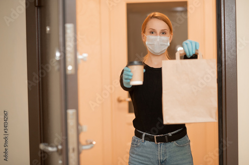 Food and coffee delivery cardboard boxes woman in protective mask. Quarantine coronavirus online shopping