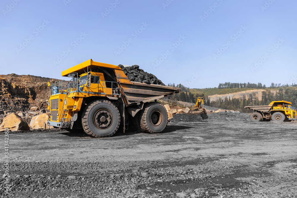 Obraz premium Big yellow mining truck for coal move. Open pit mine industry