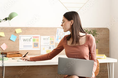 Young female designer worki...