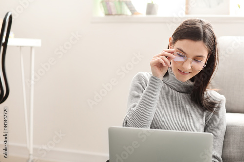 Young woman with laptop wor...