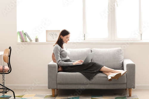 Young woman with laptop wor...