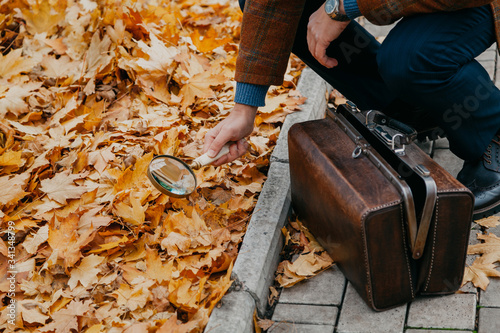 Big round magnifier on long handle in hand of naturalist