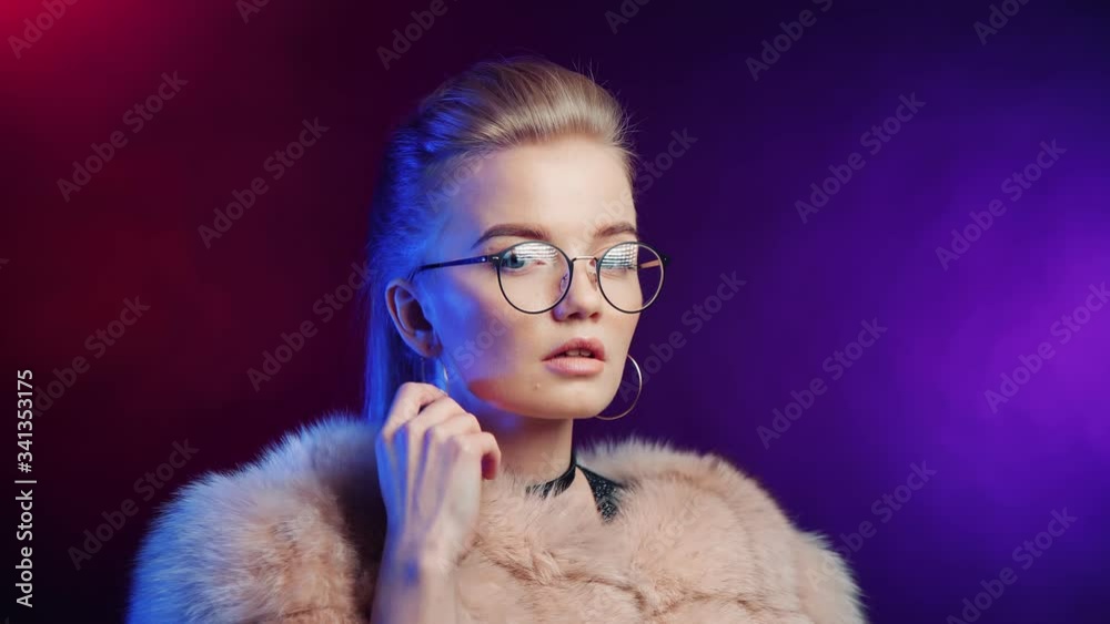 Fashionable sexy woman in fur coat relaxing at neon party nightclub isolated. 4k Dragon RED camera Fashionable sexy woman in fur coat relaxing at neon party nightclub isolated. 4k Dragon RED camera