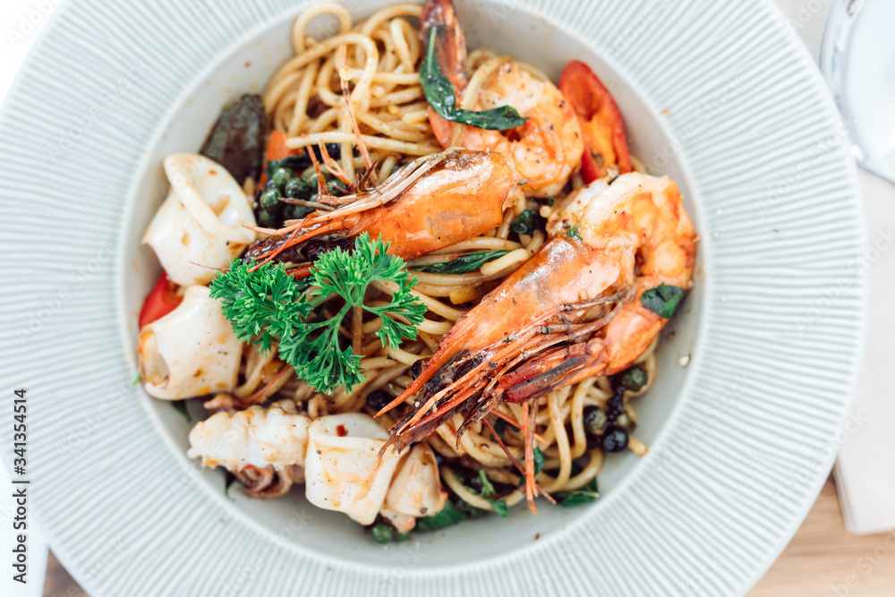 drunken spaghetti with seafood on white plate is modern Thai fusion food
