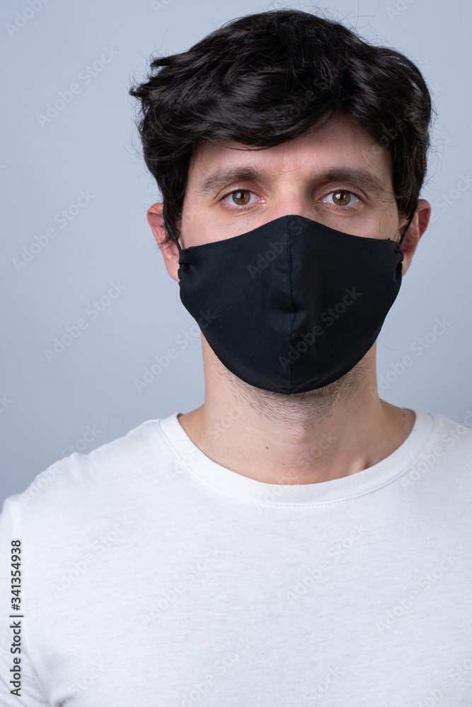 Man in a black medical mask, isolated on a gray background Man in a black medical mask, isolated on a gray background
