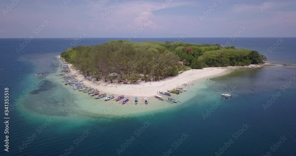 White sand island with set of national fish boats in the middle of ocean White sand island with set of national fish boats in the middle of ocean