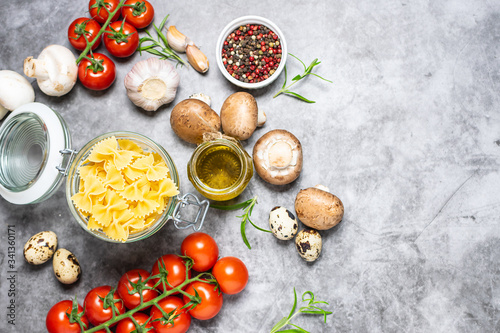 Fresh organic ingredients for cooking pasta on dark stone table top view. Healthy food concept. Culinary blog background. Traditional Italian food.