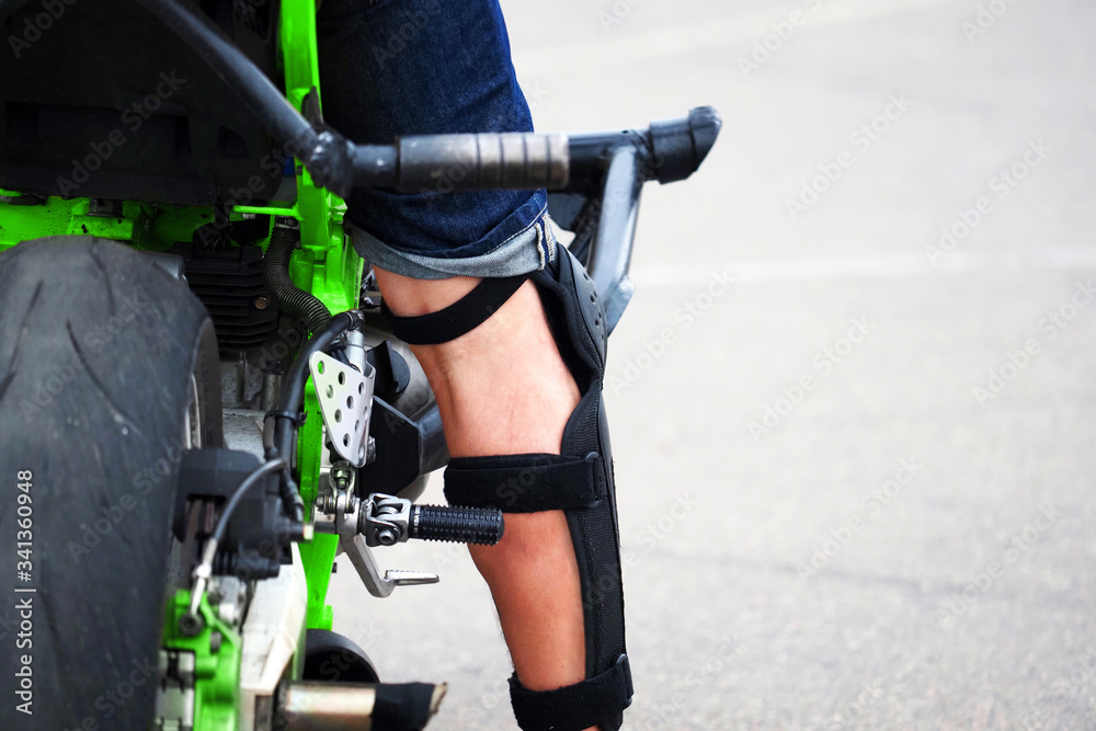 Moto rider on his motorbike, stunt riding. Knee protection Moto rider on his motorbike, stunt riding. Knee protection