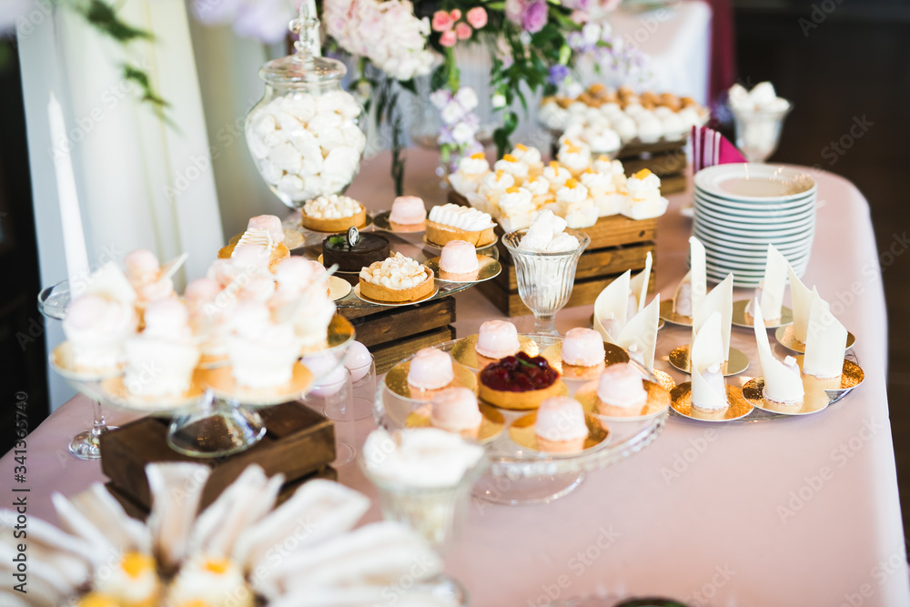Delicious sweets on wedding candy buffet with desserts, cupcakes