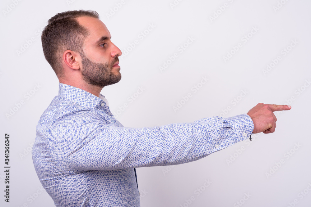 Profile view of bearded businessman pointing finger Profile view of bearded businessman pointing finger