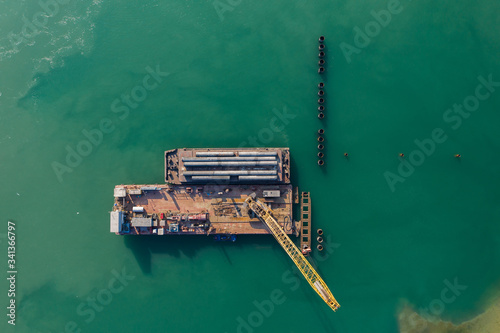  Construction of the berth from a metal sheet pile of the Larsen type, installation of piles of the berth wall with a floating crane. View from above. Aerial photography © Юлия Корниевич