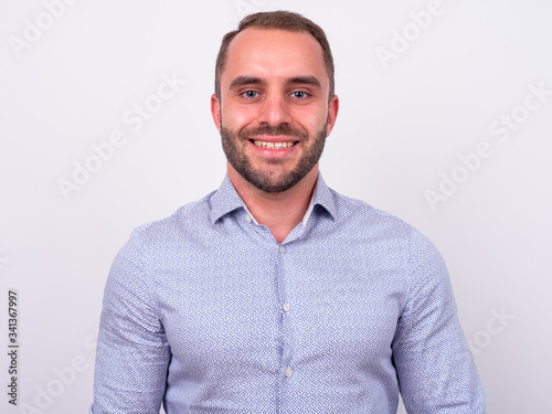 Portrait of happy bearded businessman smiling and looking at camera © Ranta Images