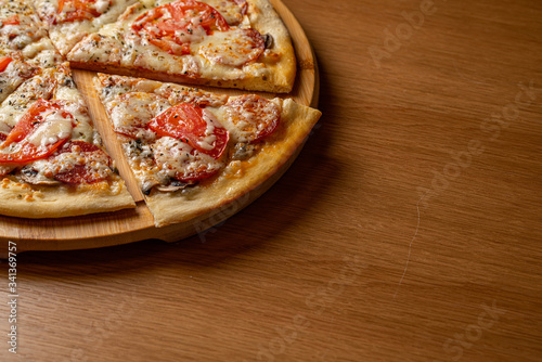 Pizza pepperoni, mozzarella, oregano on a black background
