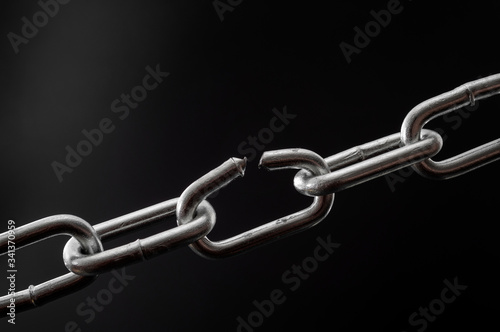 Obraz na płótnie The team is as strong as its weakest link and single point of failure concept with powerful iron chain with one stressed link breaking under physical pressure isolated on black background w salonie