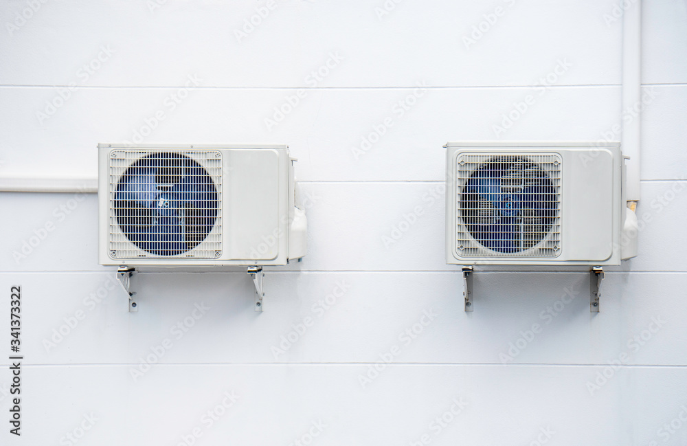 Two Air conditioner compressor on the white wall. Copy space and background. Two Air conditioner compressor on the white wall. Copy space and background.