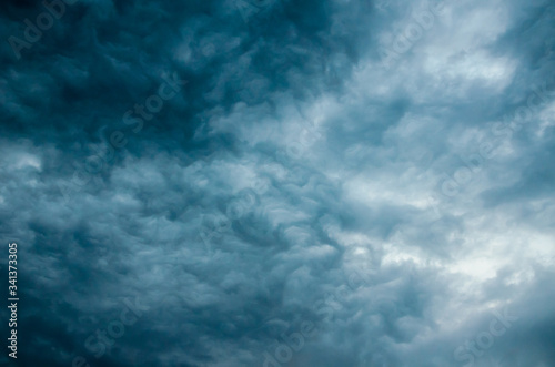 Dark blue ominous storm clouds close up overhead. Dramatic sky background. Horizontal orientation.