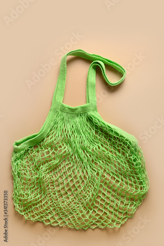 Empty red cotton eco green mesh bag on beige. Eco friendly. Top view. Vertical.