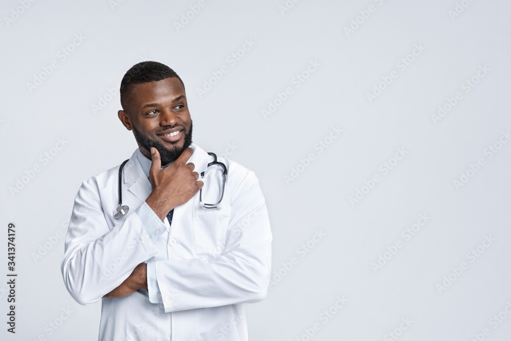 Interested african doctor in white uniform looking at copy space Interested african doctor in white uniform looking at copy space