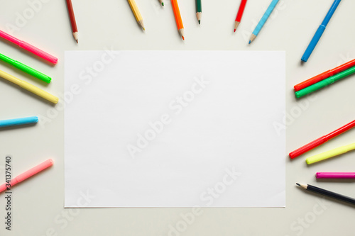 children desk with colorful pencils and white paper, top view school background with copy space