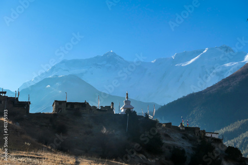Temple complex in Manang Annapurna Circuit Trek, Nepal. Stupa in front of other buildings. Temple built on a rocky mountain hills. Sacred place for many Buddhist tourists. Snow caped peaks in the back