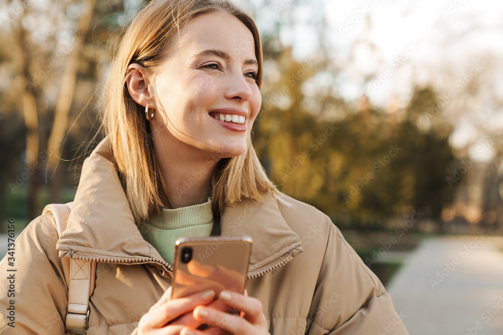 Portrait of happy blonde woman smiling and using cellphon Portrait of happy blonde woman smiling and using cellphon