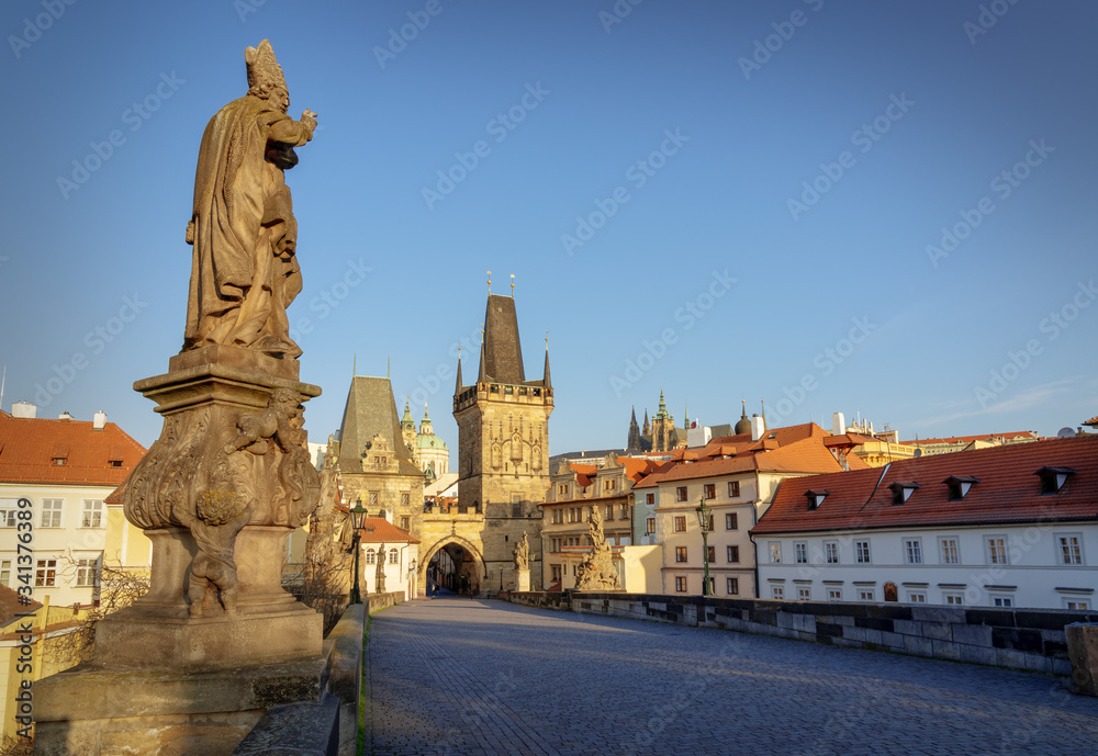 Famous Charles Bridge in Prague. Statue of St. Adalbert (Vojtech in Czech) pointing towards Lesser Town and Castle. No people on the bridge due to Covid-19 outbreak in April 2020