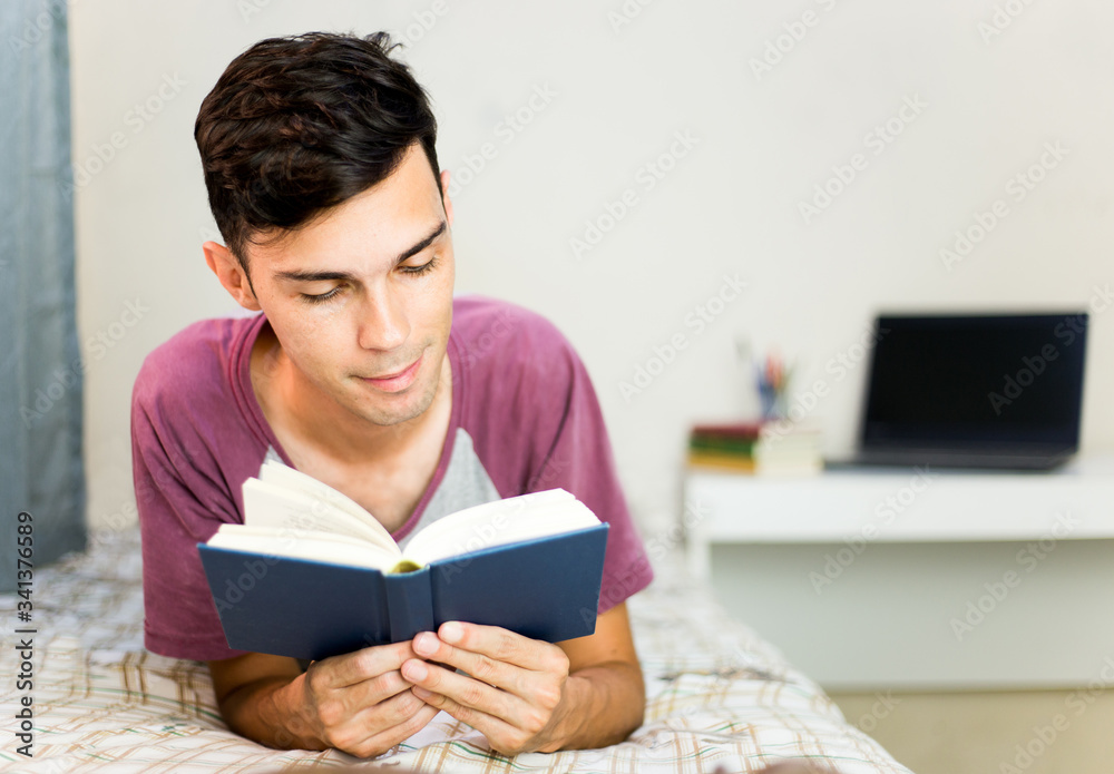 Young man in the bedroom relaxing and reading a book. Young man in the bedroom relaxing and reading a book.