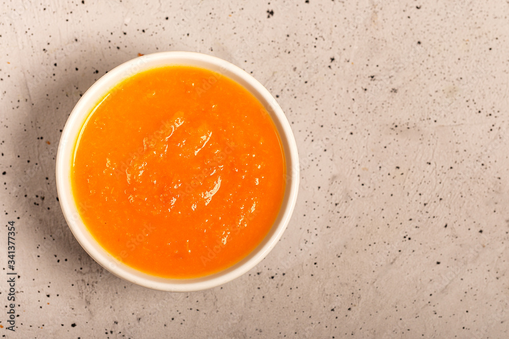 Pumpkin and carrot soup with fresh dill on concrete light background Pumpkin and carrot soup with fresh dill on concrete light background