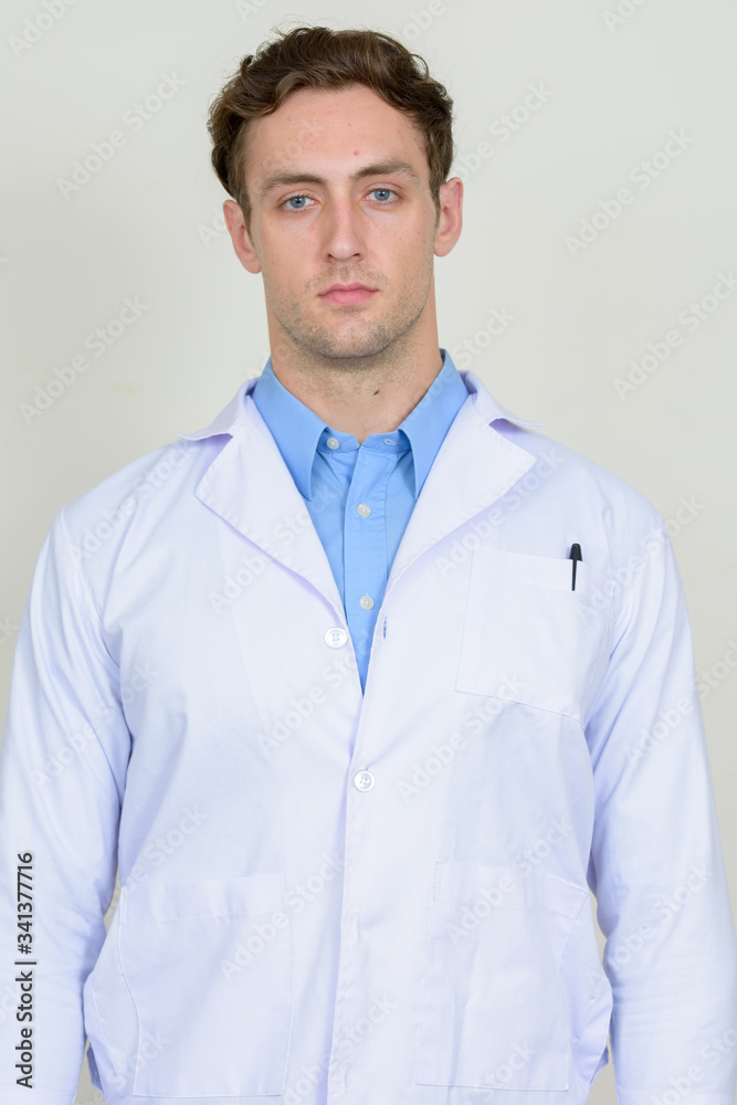 Portrait of young handsome man doctor looking at camera Portrait of young handsome man doctor looking at camera