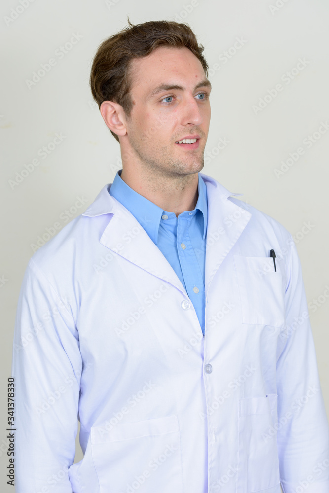 Portrait of happy young handsome man doctor thinking Portrait of happy young handsome man doctor thinking
