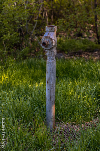 Old faucet for water in the grass