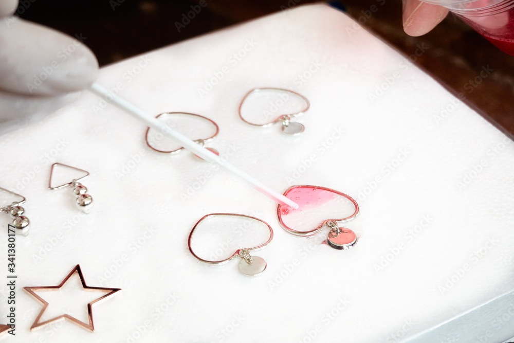 Pouring glitter pink resin to heart shaped earrings , process of prepare for make an accessories Pouring glitter pink resin to heart shaped earrings , process of prepare for make an accessories