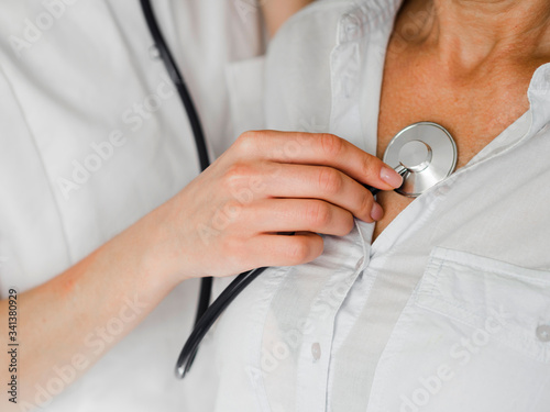 Close-up doctor checking patient with stethoscope photo