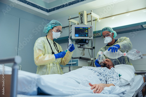 Doctors with bag valve mask caring for patient in emergency care unit of a hospital