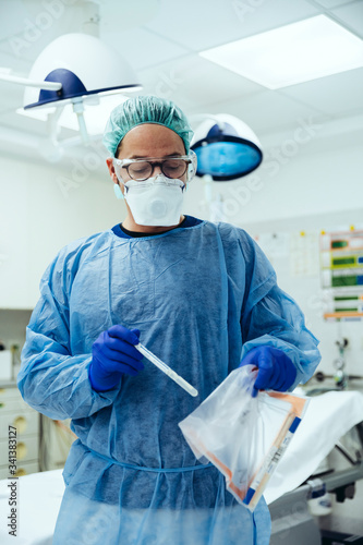 Emergeny doctor putting a swab into a plastic bag in hospital photo